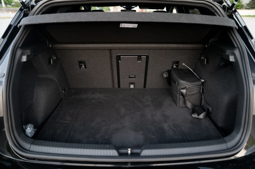 Volkswagen Golf R Black Edition Duży bagażnik samochodowy z otwartą klapą, po prawej stronie znajduje się czarna torba, wnętrze jasne i czyste, tapicerka w ciemnym kolorze.