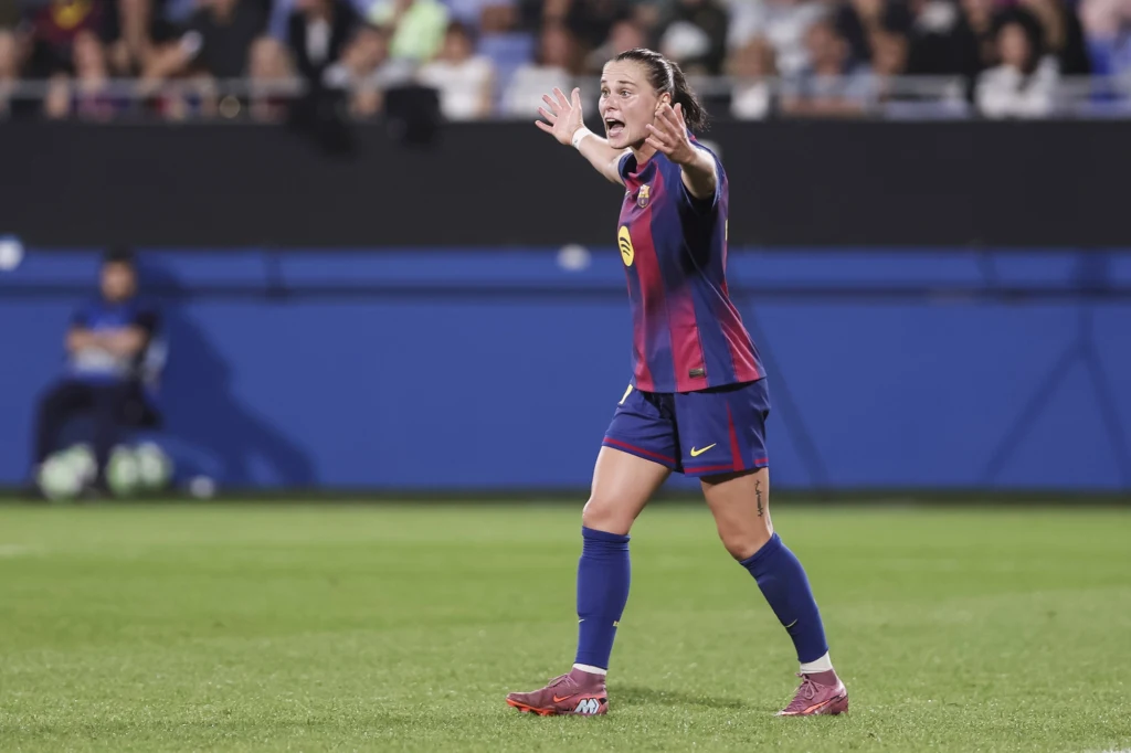 Ewa Pajor Piłkarka w stroju FC Barcelony z wyciągniętymi rękami podczas meczu na stadionie, za nią widoczny tłum kibiców na trybunach.