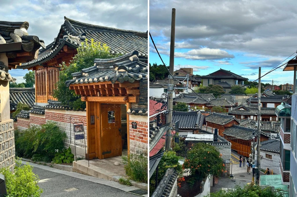 Tradycyjne koreańskie domy hanok z charakterystycznymi dachami z ciemnych dachówek ustawione w wąskich uliczkach, otoczone zielenią i niskimi murkami, inspirowane architekturą historyczną Korei.
