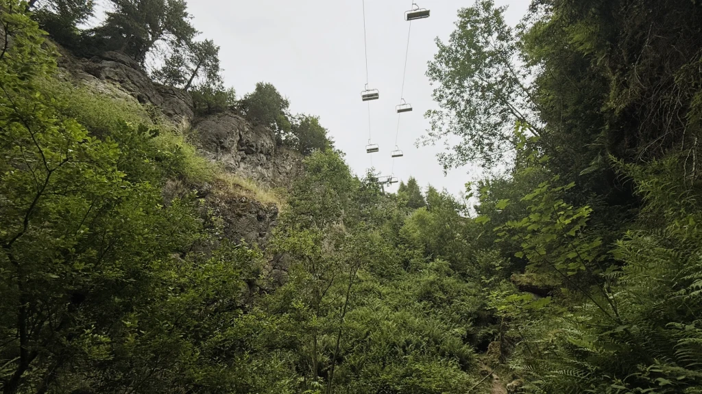 Wdżar to nie tylko anomalia i legendy, ale i miejsce pełne innych atrakcji - szczególnie dla aktywnych. Są tu trasy rowerowe i narciarskie, wyciąg oraz tor saneczkowy. Gęsty las z widoczną skałą po lewej stronie, nad którymi przebiega kolejka krzesełkowa z pustymi siedzeniami zawieszonymi nad roślinnością.