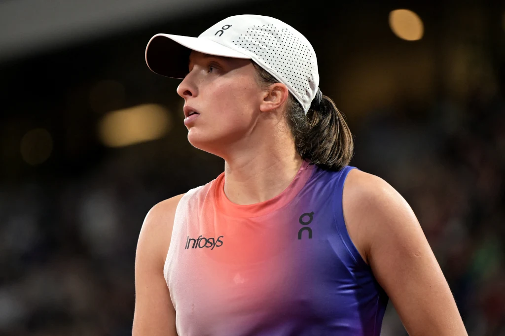 Tenisistka w sportowym stroju i czapce z daszkiem skupiona podczas meczu, tło rozmyte, intensywność wydarzenia podkreślona mimiką.