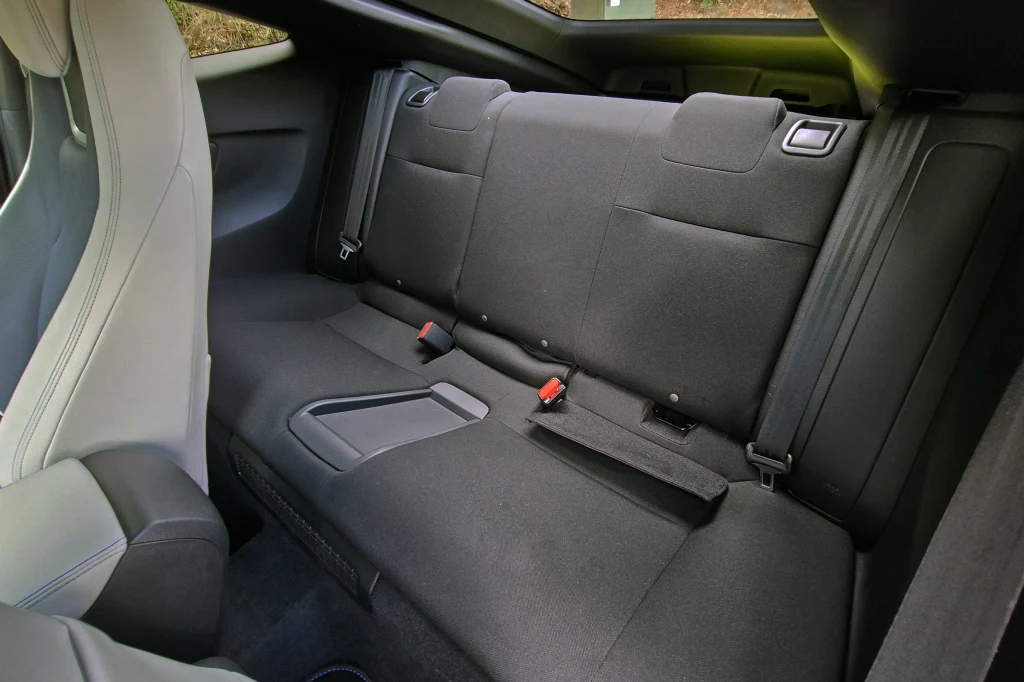 Podróżni z tyłu traktowani są w nowym Prelude po macoszemu. Nie chodzi tylko o śladową ilość miejsca, ale także zupełnie inną tapicerkę i kolorystykę niż z przodu Tylna kanapa samochodu wykończona czarną tapicerką, dwa zagłówki, dwa pasy bezpieczeństwa oraz plastikowy element w środkowej części oparcia.