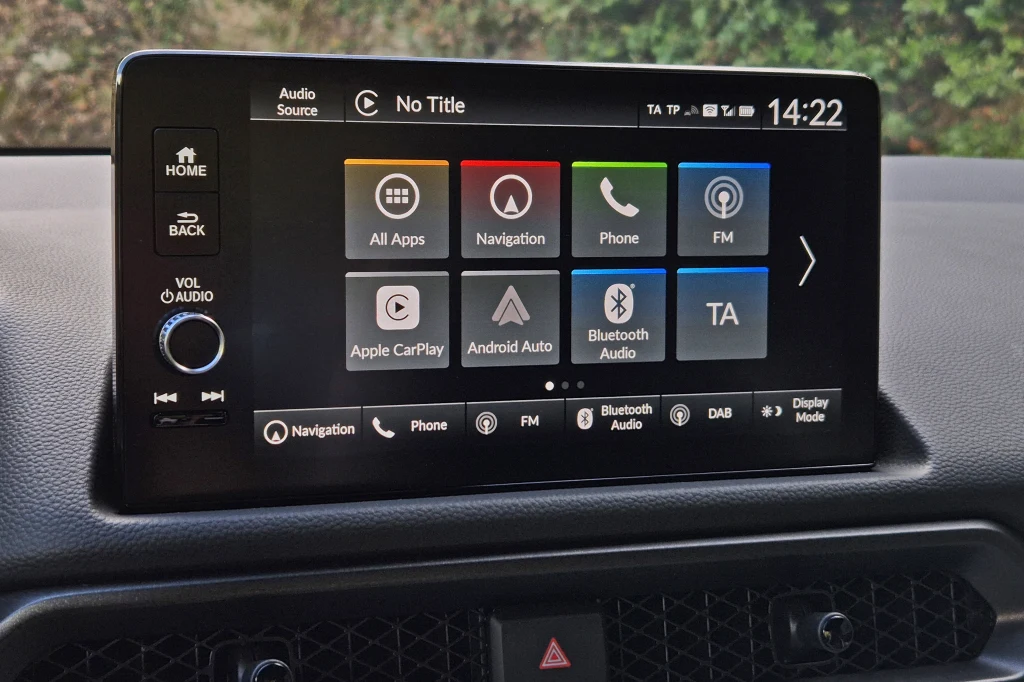 System multimedialny z 9-calowym wyświetlaczem jest prosty w obsłudze, ale wygląda dość archaicznie Kolorowy wyświetlacz w konsoli samochodu prezentuje menu systemu multimedialnego z ikonami do nawigacji, telefonu, radia FM, aplikacji Apple CarPlay oraz Android Auto. Na górze ekranu widoczne są informacje o godzinie i statusie połączeń.