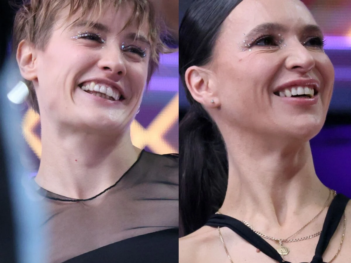 Katarzyna Zillmann i Janja Lesar Dwie kobiety z szerokimi uśmiechami na twarzach, w wieczorowych stylizacjach z połyskującym makijażem, sfotografowane na tle jasnych i kolorowych świateł, charakterystycznych dla sceny lub programu telewizyjnego.