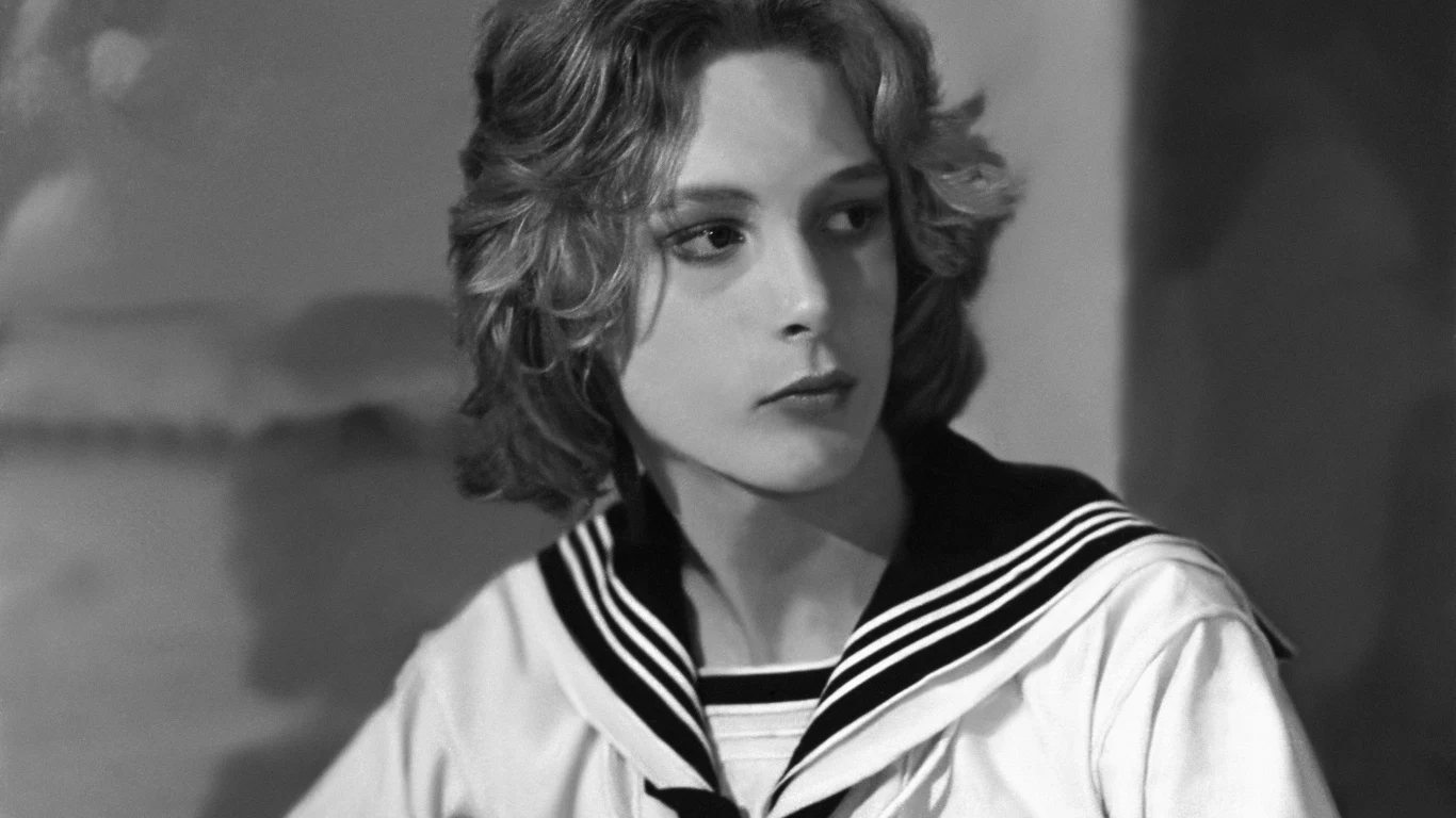 Björn Andrésen, 1971 r. Młoda osoba o jasnych, falowanych włosach w marynarskim stroju siedzi w zamyśleniu i patrzy na bok. Tło rozmyte, skupienie na twarzy i ubiorze.