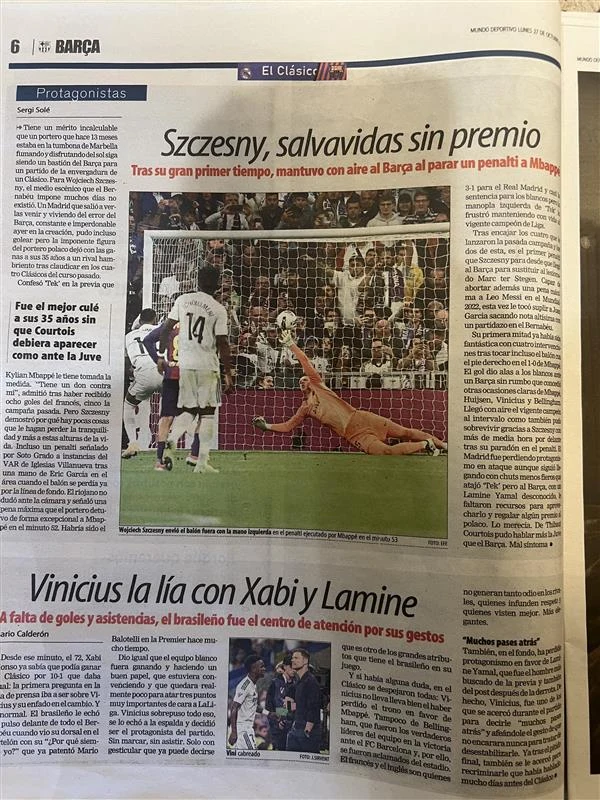 Hiszpańskie media wiele uwagi poświęciły Wojciechowi Szczęsnemu Piłkarz uderza piłkę z rzutu karnego, podczas gdy bramkarz rzuca się w kierunku lecącej piłki, próbując ją obronić. W tle widoczna jest publiczność na stadionie oraz kilku zawodników obserwujących sytuację.