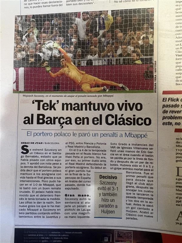 Tak Hiszpanie piszą o Wojciechu Szczęsnym Polski bramkarz w żółtym stroju rzuca się, by obronić rzut karny, podczas gdy napastnik w białym stroju znajduje się tuż obok piłki nad boiskiem. W tle widoczni kibice na trybunach oraz piłkarska bramka. Arkusz gazety zawiera tytuł artykułu oraz tekst ...