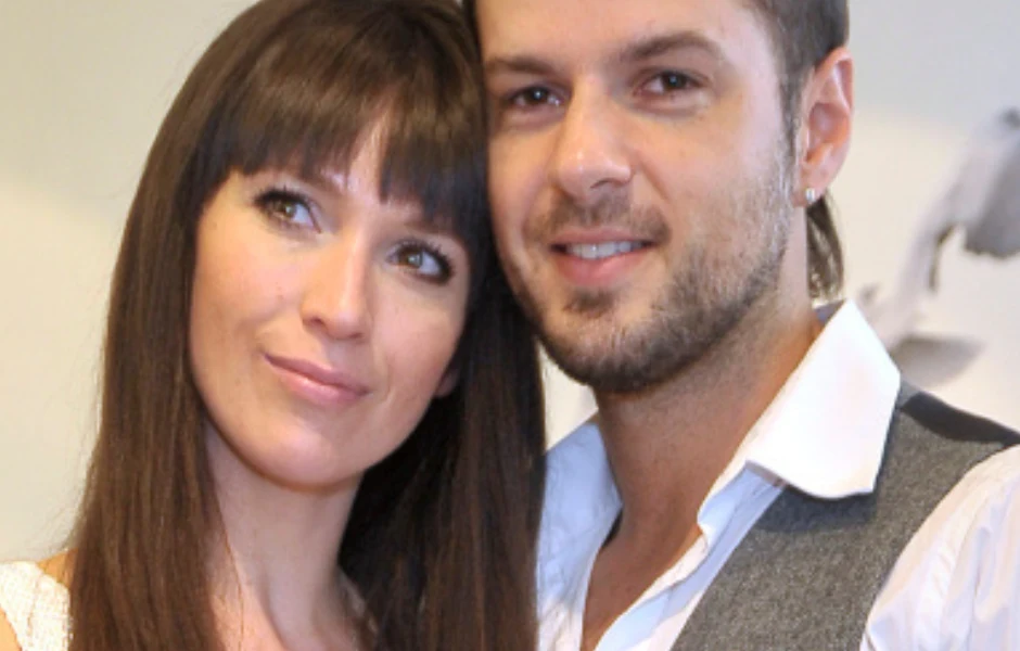 Janja Lesar, Krzysztof Hulboj Para młodych ludzi stojąca blisko siebie, kobieta o długich ciemnych włosach oraz mężczyzna z zarostem i lekkim uśmiechem, oboje wyglądają na zadowolonych oraz swobodnych.