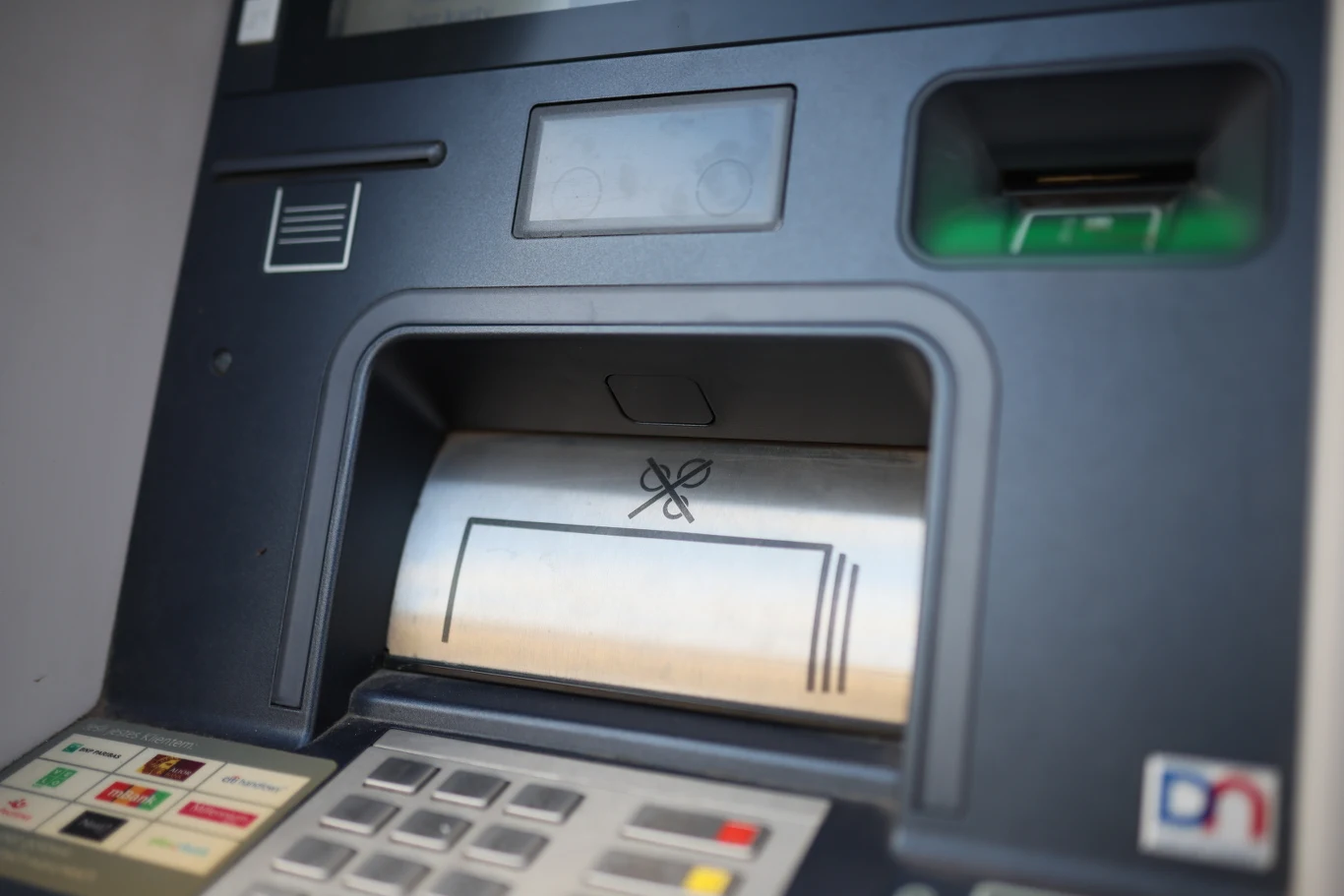 Z kont 490 klientów banku Santander skradziono 2,2 mln zł Bankomat zbliżony w kadrze, widoczne kolorowe przyciski, czytnik kart oraz miejsce na wypłatę banknotów z symbolem motyla.