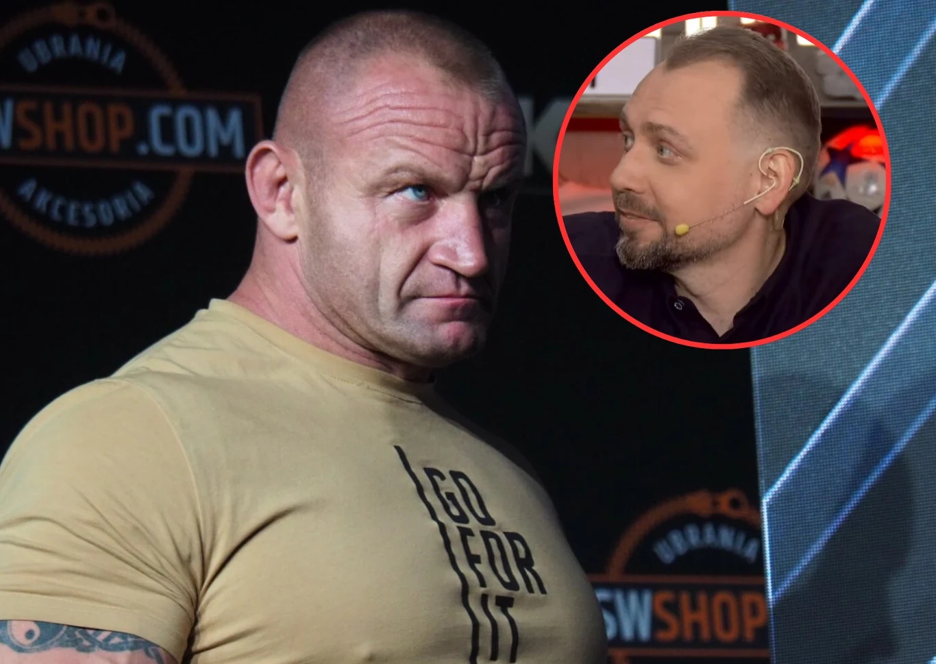 Mężczyzna o atletycznej budowie w jasnej koszulce z napisem, stojący na tle planszy reklamowej; w górnym rogu znajduje się okrągłe wstawienie z profilem innego mężczyzny rozmawiającego w studiu.