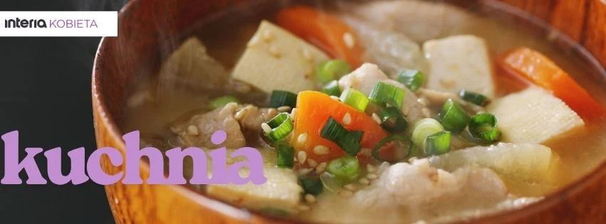 Kuchnia Zupa z kawałkami tofu, marchewką, zieloną cebulką, sezamem oraz kawałkami mięsa podana w drewnianej misce.