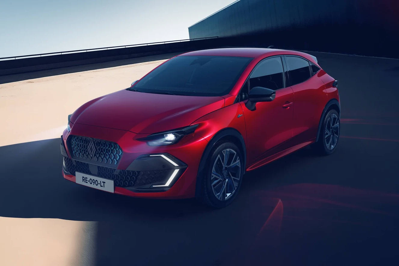 Nowe Renault Clio dostępne jest ze 115-konną jednostką benzynową i 160-konnym układem hybrydowym. Czerwony nowoczesny samochód sportowy o dynamicznym wyglądzie, stojący na jasnej powierzchni w cieniu, z charakterystycznym sześciokątnym grillem i nowoczesnym oświetleniem LED.