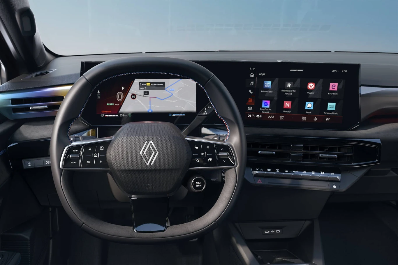 Renault Clio dostępne jest w trzech wersjach wyposażenia. Widok nowoczesnej deski rozdzielczej samochodu Renault, centralne miejsce zajmuje kierownica z charakterystycznym logo, za nią wyświetlacze cyfrowe prezentujące nawigację i system multimedialny, otoczone minimalistycznym wnętrzem.