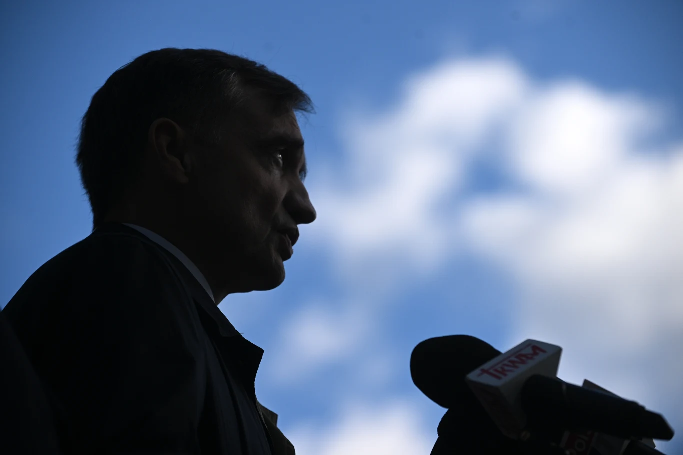 Zbigniew Ziobro jest de facto oskarżany o bycie szefem mafii Sylwetka mężczyzny przemawiającego do mikrofonów na tle nieba z widocznymi obłokami, twarz w cieniu, widać wyraźne zarysy oraz elementy sprzętu nagłaśniającego.