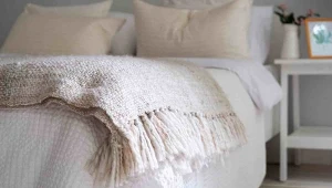 Jasna kolorystyka, miękkie faktury i naturalne dodatki tworzą spokojną sypialnię w stylu boho |