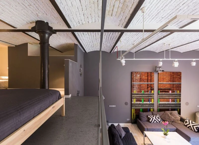 Niska, niemalże niewidoczna na tle podłogi i ścian balustrada z metalu i szkła sprawia, że antresola wydaje się zupełnie otwarta i uniesiona ponad ...