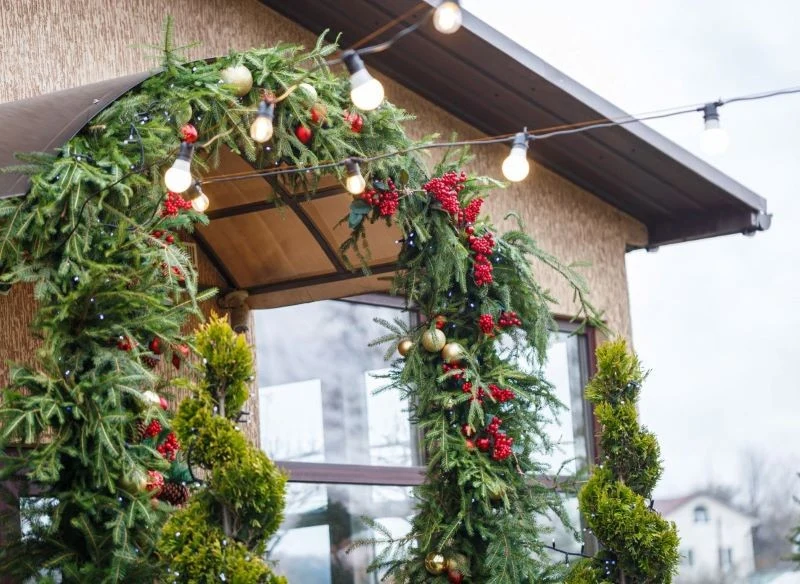 Spójna dekoracja świetlna przy schodach, wokół wejścia i na okolicznych drzewkach da piękny efekt