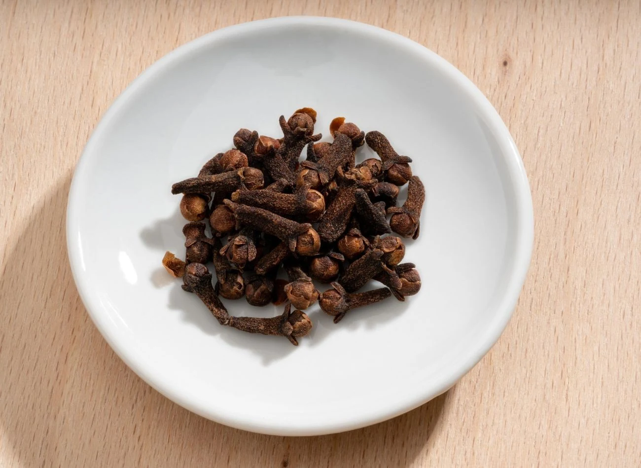 Garstka goździków umieszczona na małym talerzyku, postawiona na jednej z półek lodówki szybko chłodnie nieprzyjemne zapachy