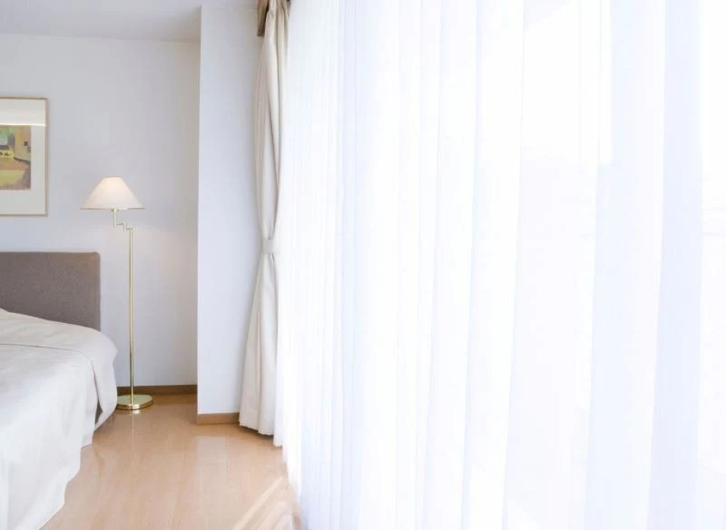 Białe, idealnie czyste firany rozświetlają pomieszczenie