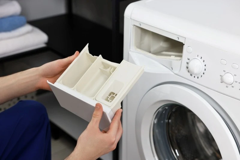 Czyszczenie szuflady na detergenty należy rozpocząć od wyjęcia jej z pralki
