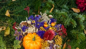 Stroik na grób może mieć jesienne akcenty w postaci miniaturowej dyni czy suszonych kwiatów.