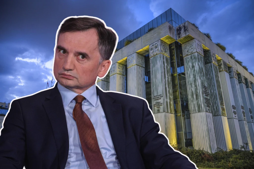 Mężczyzna w garniturze z poważnym wyrazem twarzy na tle nowoczesnego budynku o kolumnowej fasadzie, z podświetleniami oraz wczesnowieczornym niebem w tle.