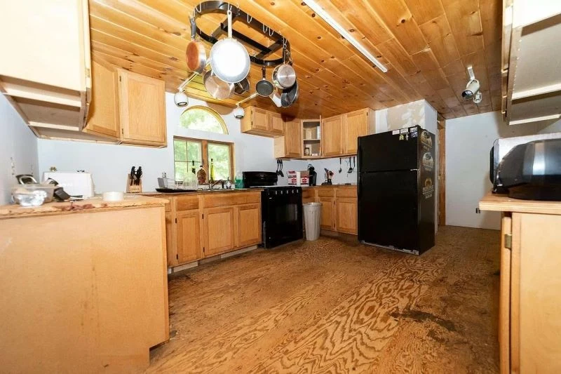 Drewniana kuchnia w prostym stylu z półokrągłym oknem ma w sobie coś wyjątkowego, potrzebuje tylko odświeżenia