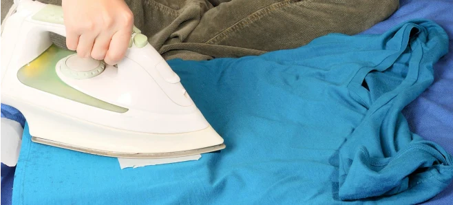 Aby usunąć plamę wosku na ubraniu, używamy ręczników papierowych i żelazka