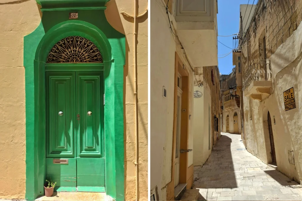 Rabat na Gozo Zielone ozdobne drzwi kamienicy na tle beżowej elewacji po lewej stronie, po prawej wąska, słoneczna uliczka z jasnymi, zabytkowymi budynkami i tablicą 'na sprzedaż' na jednej ze ścian.