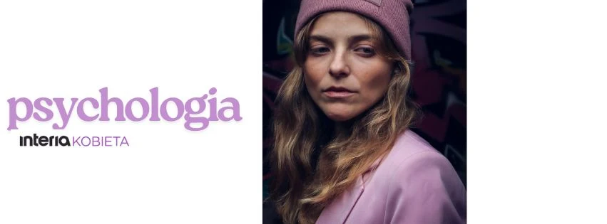 Zrozum swoje emocje i odkryj, jak wpływają na codzienne wybory Kobieta o długich blond włosach w różowej czapce i jasnej marynarce na tle ciemnego, rozmytego tła, obok napis 'psychologia' oraz logo 'interia kobieta'.