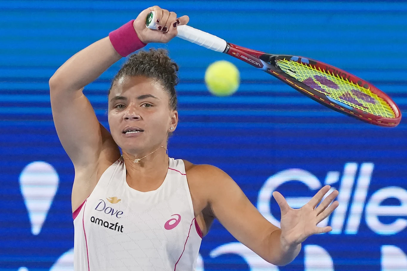 Jasmine Paolini Tenisistka w trakcie dynamicznego uderzenia piłki rakietą na korcie, skupienie na twarzy, widoczne detale stroju sportowego i logotypy sponsorów.