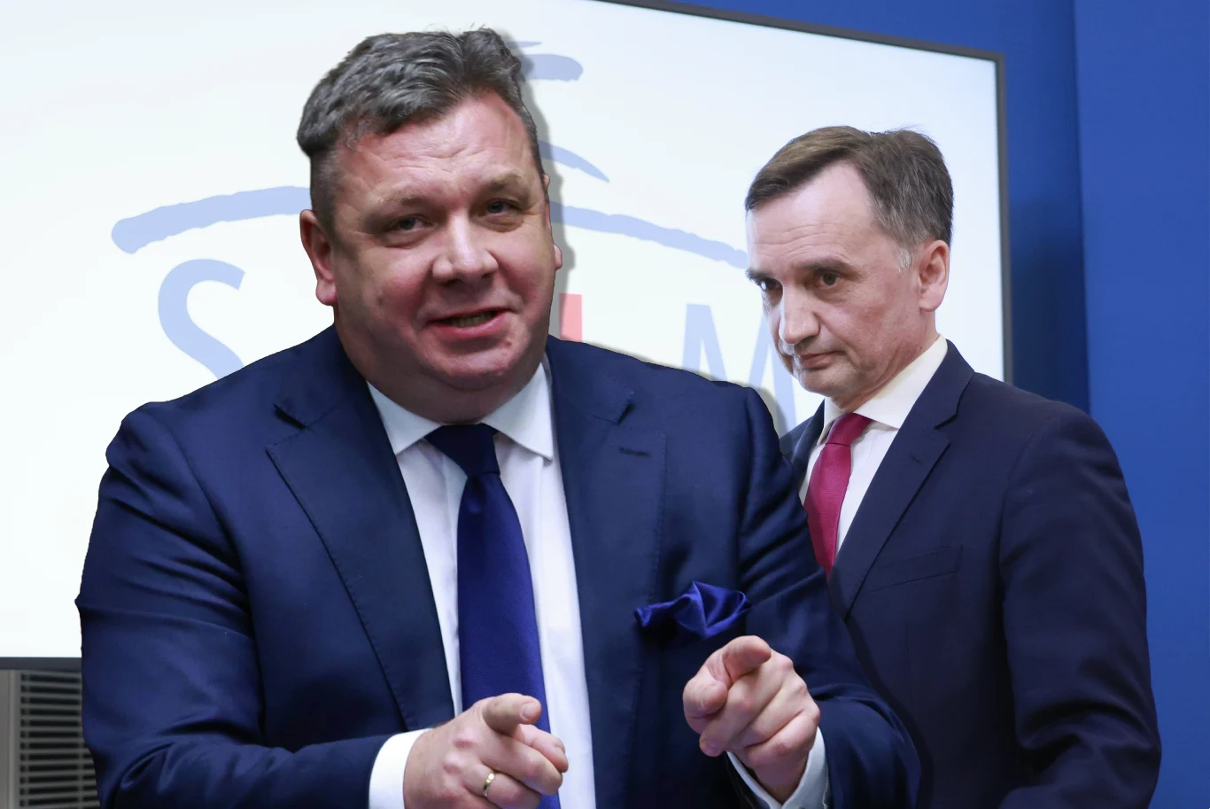 Michał Wójcik w wywiadzie dla Interii mówił m.in. o sytuacji Zbigniewa Ziobry Dwóch mężczyzn w garniturach na tle ekranu z logo, jeden z nich gestykuluje dłońmi, drugi stoi z poważnym wyrazem twarzy, obaj skupieni i elegancko ubrani.