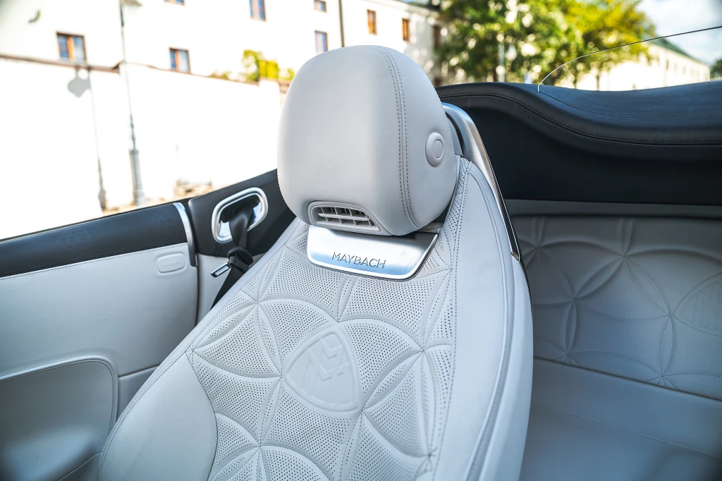 Luksusowy skórzany fotel samochodu z wyhaftowanym logo Maybach, widoczne detale wysokiej jakości, wentylacja zagłówka i przemyślane wykończenie wnętrza