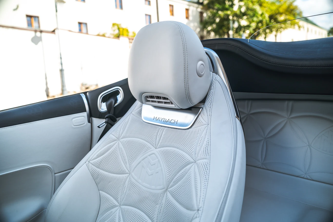 Luksusowy skórzany fotel samochodu z wyhaftowanym logo Maybach, widoczne detale wysokiej jakości, wentylacja zagłówka i przemyślane wykończenie wnętrza