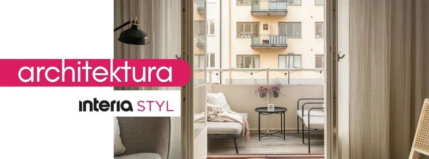 Przytulny balkon z widokiem na sąsiadujące bloki mieszkalne, z ustawionymi dwoma sofami, stolikiem oraz dekoracją w postaci wazonu z kwiatami, delikatnie oświetlony naturalnym światłem wpadającym przez otwarte drzwi balkonowe.