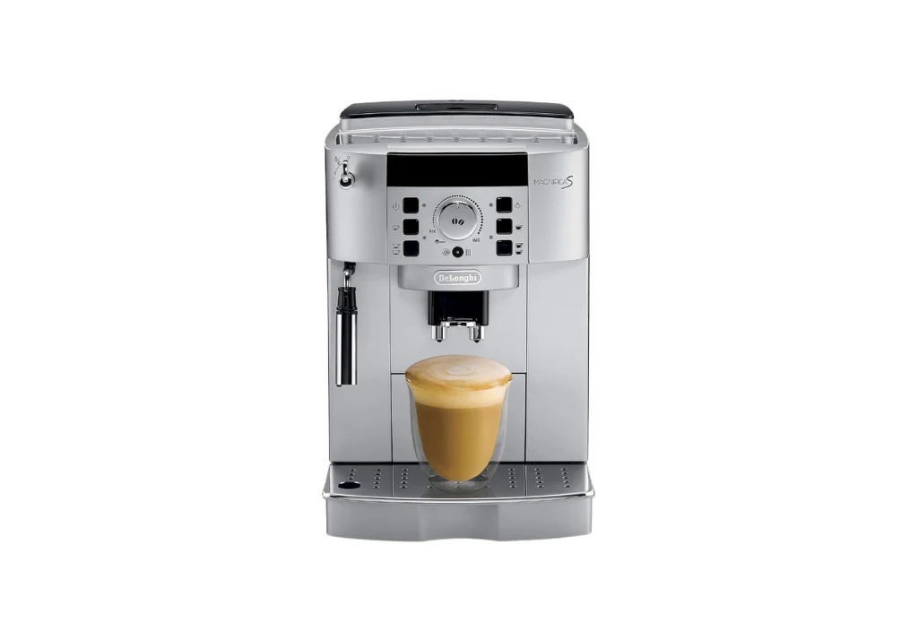 Automatyczny ekspres do kawy w srebrnej obudowie z panelem sterowania, pod którym stoi szklanka z kawą cappuccino z gęstą pianką.