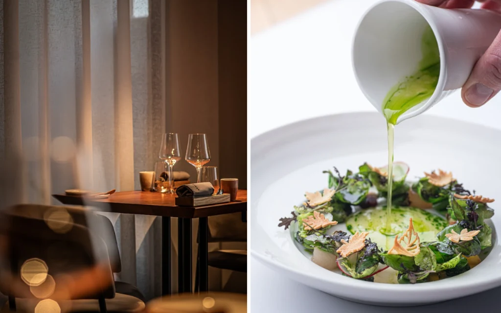 Stół restauracyjny z eleganckimi nakryciami oraz kieliszkami ustawionymi przy ciepłym świetle, obok misternie przygotowane danie z zielonym sosem polewanym na talerz ozdobiony świeżymi liśćmi, ziołami i chrupiącymi dekoracjami.