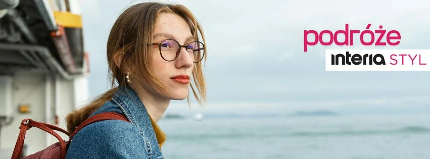 Młoda kobieta w okularach z rudymi włosami, ubrana w dżinsową kurtkę i z plecakiem, stoi na tle rozmytego krajobrazu wodnego, z boku widoczny fragment statku. Po prawej stronie widoczne kolorowe napisy: podróże interia STYL.
