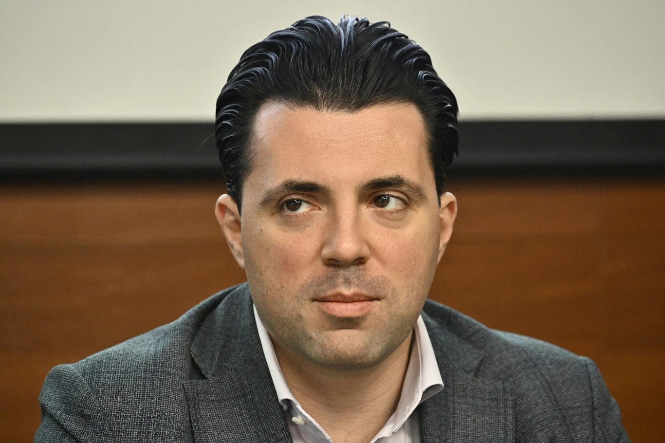 Wołodymyr Kudricki, były szef ukraińskiego operatora energetycznego Ukrenergo Mężczyzna w szarej marynarce i białej koszuli siedzi na tle brązowej ściany, z zaczesanymi do tyłu włosami, patrzy lekko w bok, wyrażając skupienie i powagę.