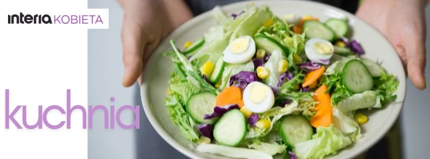 Poznaj przepisy, które łączą smak, zdrowie i domowe ciepło Kolorowa sałatka z plasterkami ogórka, jajeczek przepiórczych, kawałkami marchewki, kukurydzą, czerwonej kapusty i sałatą na jasnym talerzu, trzymanym przez dwie ręce.