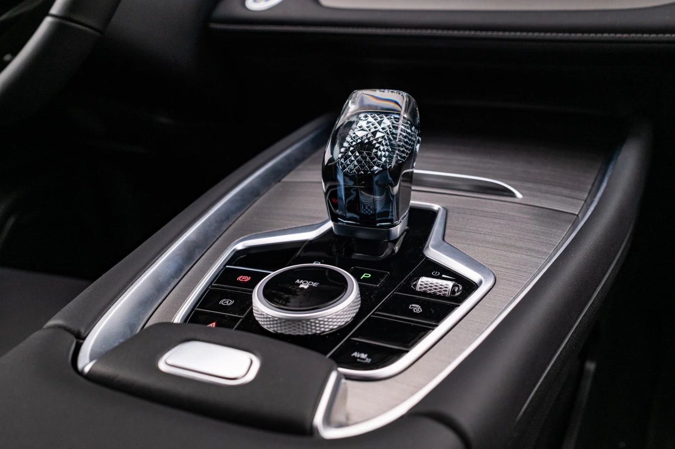 “Kryształowa” dźwignia zmiany biegów, widać inspiracje modelami BMW. Dużym pokrętłem wybiera się jeden z trzech trybów jazdy. Luksusowa, designerska dźwignia zmiany biegów z detalami z przezroczystego materiału otoczona panelami z przyciskami funkcyjnymi i pokrętłem sterującym, umieszczona na eleganckiej, matowej konsoli centralnej samochodu.