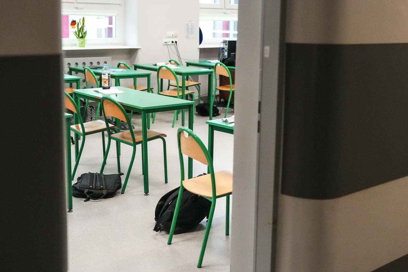 Kalendarz roku szkolnego 2026/2027 Klasa, ławki, rozrzucone na podłodze plecaki