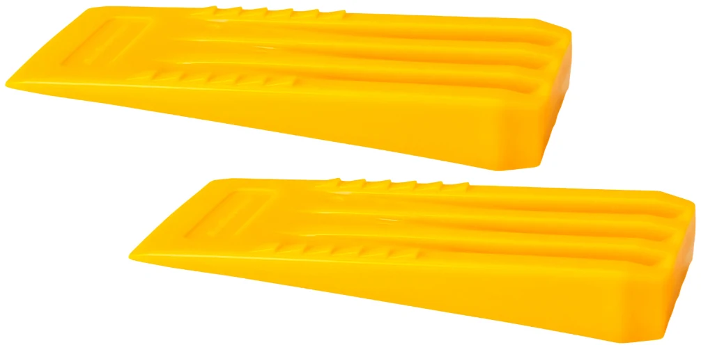 Dwa plastikowe, żółte kliny z wyżłobieniami na powierzchni, służące jako podstawki lub zabezpieczenie dla kół pojazdów.