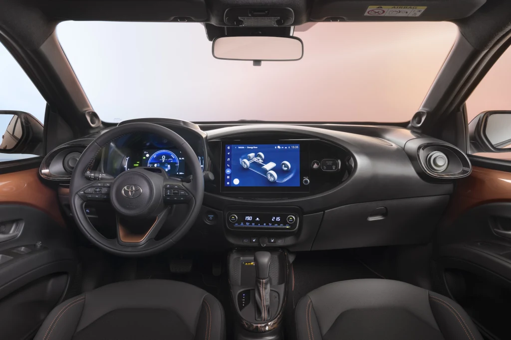 Największą nowością w kabinie jest większy ekran centralny Nowoczesne wnętrze samochodu z dużym dotykowym ekranem centralnym, cyfrowym zestawem wskaźników, wielofunkcyjną kierownicą i automatyczną skrzynią biegów, wykończone stylowymi detalami w odcieniach czerni i brązu.