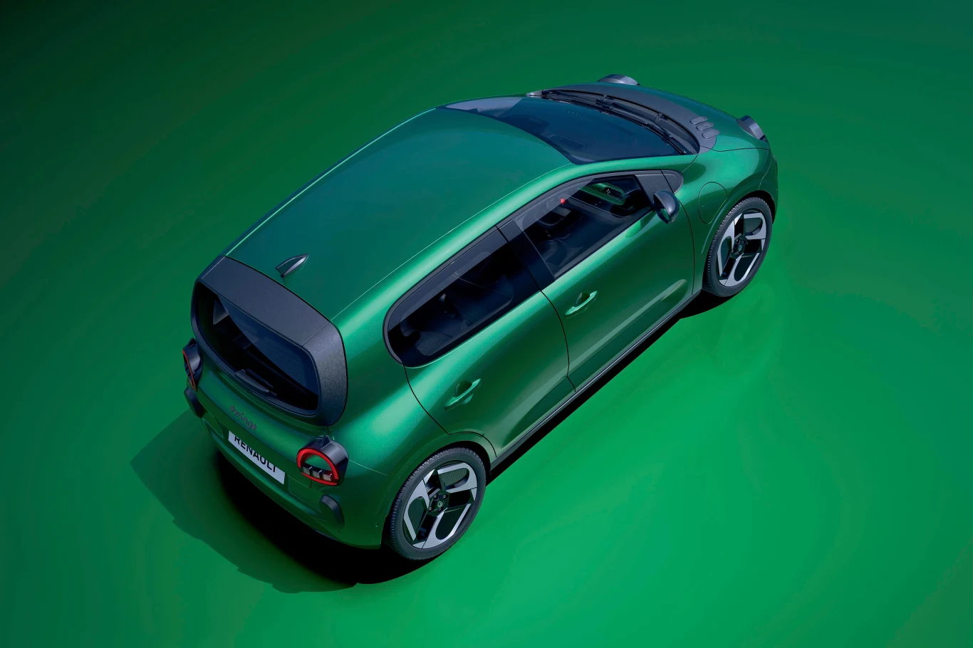 Zielony samochód osobowy widziany z góry na jednolitym, zielonym tle. Pojazd ma nowoczesny design, czarne szyby i wyraźnie zarysowane detale nadwozia.