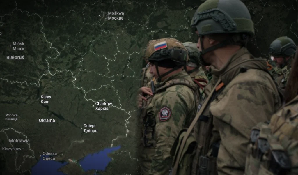 Rosja testuje nowy system Grupa żołnierzy w mundurach wojskowych z rosyjską flagą na ramieniu stoi na tle mapy przedstawiającej Ukrainę i sąsiednie kraje, widoczne są nazwy miast i granice państw.