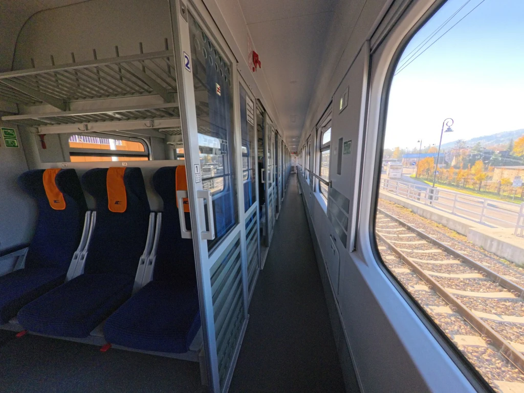 PKP Intercity zaalarmowała służby po tym, jak prezes spółki dostał wiadomości od właściciela konkurencyjnego RegioJet Puste siedzenia w nowoczesnym wagonie pociągu z dużymi oknami, przez które widać peron oraz fragment torów i krajobraz z jesiennymi drzewami.