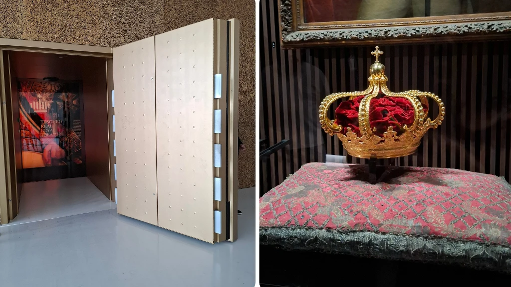 Złota korona ozdobiona detalami leży na czerwonej poduszce w szklanej gablocie, obok widoczne duże, otwarte drzwi sejfu prowadzące do wnętrza skarbca.
