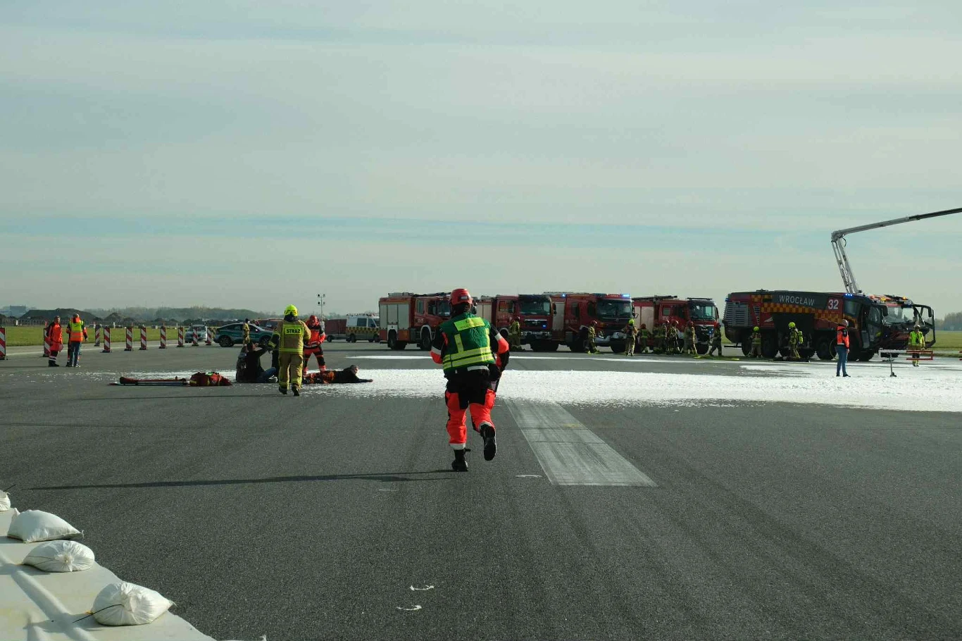 Na miejscu byli też statyści, odgrywający role poszkodowanych pasażerów. Strażacy i ratownicy medyczni prowadzą działania przy pasie startowym na lotnisku, wokół rozlanej piany gaśniczej i z udziałem wielu wozów strażackich oraz ratowniczych.