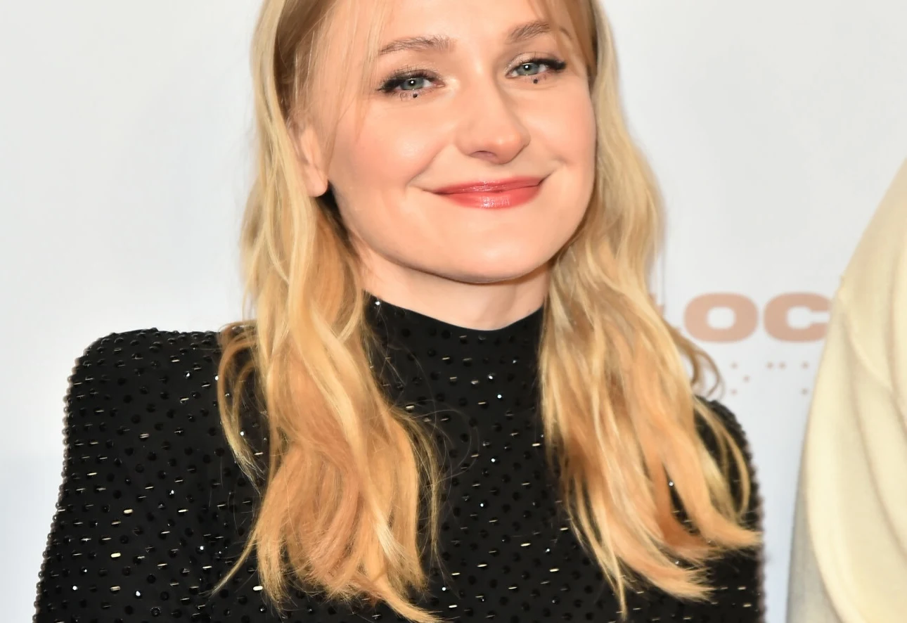 Kaśka Sochacka niewiele mówi o swoim życiu prywatnym Uśmiechnięta kobieta o blond włosach w czarnej, zdobionej sukience na jasnym tle, patrząca prosto w obiektyw.